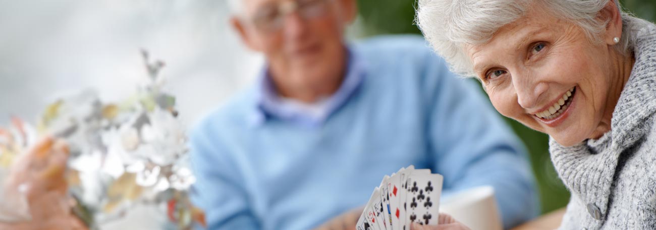 a very attractive older couple enjoying playing a card game