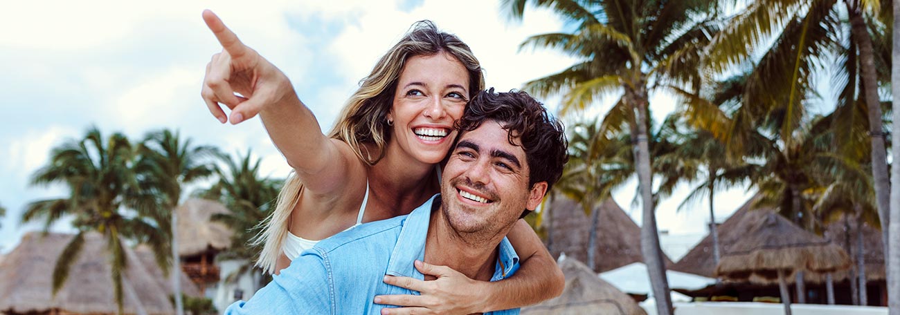 a happy young couple enjoying a frolic on a Caribbean island beach